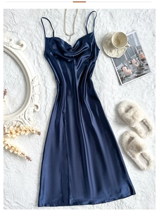 Close-up of navy blue satin slip dress with cowl neck on luxury white faux fur