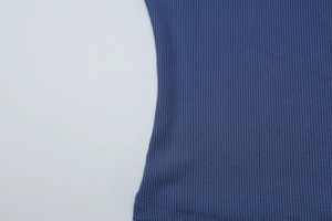 Détail du tissu en maille côtelée bleu marine montrant l'ourlet et la texture