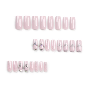 Sparkly pink and silver glitter press-on nails with rainbow rhinestones in long square shape