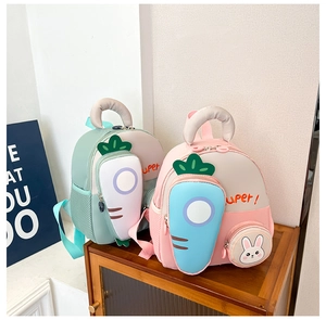 Detail of cartoon kids backpack featuring 3D carrot pocket and bunny coin purse charm