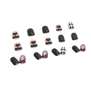 Faux ongles à coller avec motifs de cœur noirs et blancs et grille en losange
