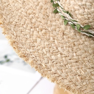 Handmade raffia sun hat with wide brim, green leaf decor and fringe edges for summer beach