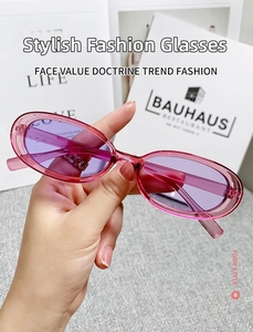 Close-up of translucent pink oval sunglasses with light purple lenses and retro design