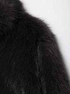 Close-up of high-density black faux fur material with soft luxurious texture and long hair