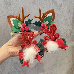 Hand holding festive Christmas bow hair clips with plush details and glitter finish