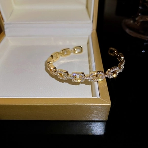 Close-up of gold-plated chain link bangle with sparkling cubic zirconia on jewelry box