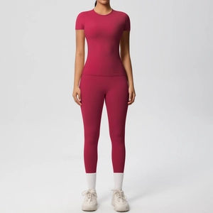 Detail view of high-waist yoga leggings and short-sleeve gym top in deep dark rose pink