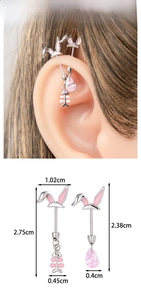 Detailed view of silver rabbit ear cartilage earrings with pink zircon and fish bone pendant