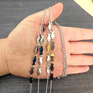 Hand holding multiple colorful minimalist fish pendants to show actual product size
