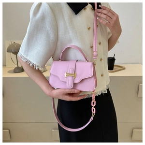 Pink PU leather crossbody bag with golden buckle and chain strap shown on model
