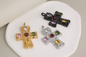 Detailed close-up of retro cross pendants in gold, silver and black with colorful stones