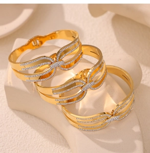 Détail de trois bracelets nœuds plaqués or 18 carats ornés de cristaux blancs brillants