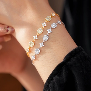 Detail of adjustable gold and silver plated floral square chain bracelet on female wrist