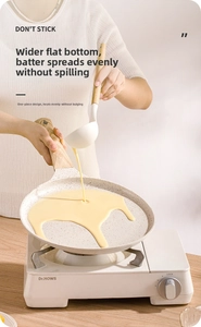 Detail showing non-stick crepe pan on a portable stove with a wide flat base and wooden handle