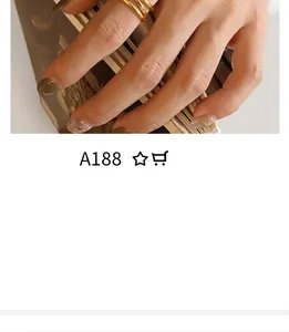 Detailed view of a gold double-row crisscross ring worn by a model in a warm setting