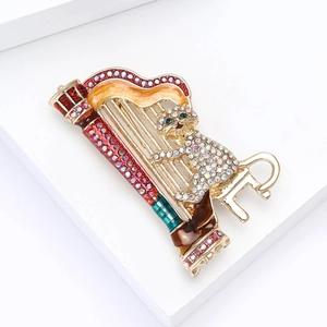 Detailed view of cat playing harp brooch with colorful rhinestones and gold alloy