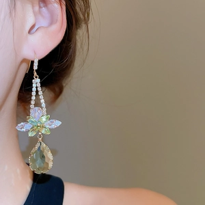 Detailed close-up of a zircon flower teardrop pendant earring worn by a model