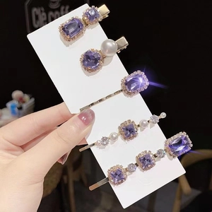 Set of five purple crystal hair clips with white pearls on golden metal bases
