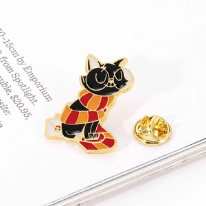 Detailed close-up of a black cat enamel pin with round glasses and a striped scarf
