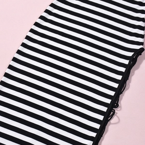 Dettaglio della maglia a coste a righe bianche e nere con design stringato sui lati della veste