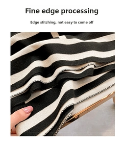 Detail showing the overlock stitched edges and thick knit texture of the striped scarf