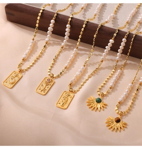 Close-up of vintage pearl necklaces with agate pendants on beige silk fabric