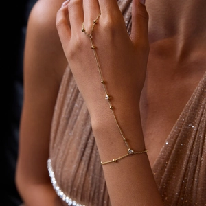 Close-up of 18K gold plated finger bracelet featuring pear-cut zircon and fine chain link