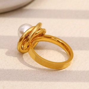 Détail macro de perle blanche sur bague en acier inoxydable plaqué or 18K style enveloppé