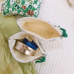 Floral cotton pouch with green cord handle showing interior storage space for accessories