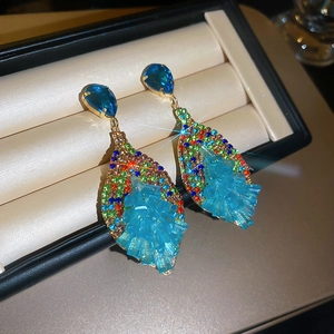 Macro shot of bohemian crystal drop earrings with multi-color rhinestones and blue clusters