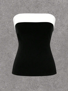 Detailopname van zwart-witte contrast strapless top met witte rand op cement achtergrond