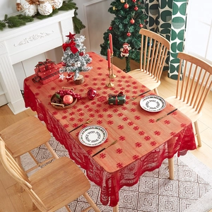 Detail of red Christmas lace tablecloth with snowflake patterns in a cozy dining room