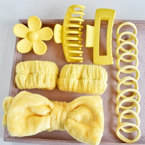 Detail view of 16-piece bright yellow hair accessory set with velvet tray and coral fleece bands