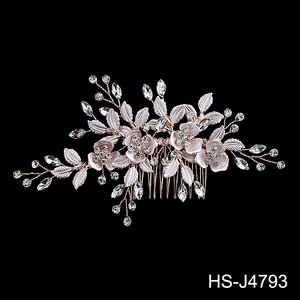 Detail of rose gold bridal hair comb with crystal flowers, rhinestones and delicate leaves