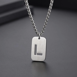Vue détaillée d'un pendentif rectangulaire argenté avec la lettre L évidée en acier
