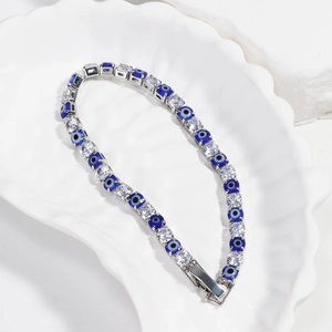 Detailed close-up of Evil Eye tennis bracelet with blue beads and zircons on white tray
