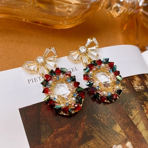 Detail of elegant bow earrings with colorful crystals and pearls on a magazine page