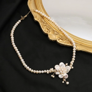 Baroque petal freshwater pearl necklace with flower pendant on black velvet background