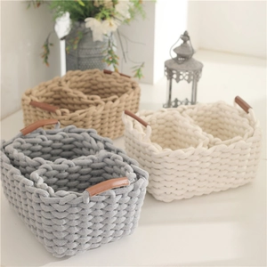 Three-piece set of woven cotton rope storage baskets with leather handles in neutral tones