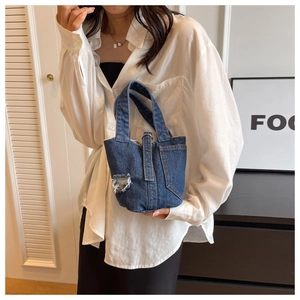Chic distressed denim bucket bag shown as a stylish handheld accessory for daily casual outfits