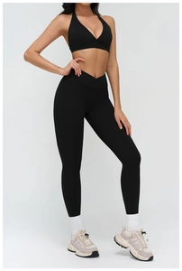 Detail of high-waisted black yoga leggings with V-shaped waistband and side pockets