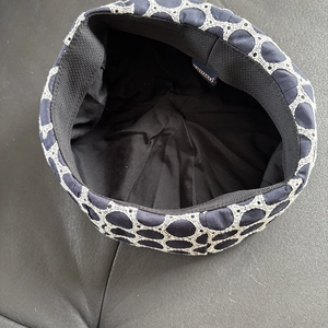 Detailed view of embroidery pattern and internal lining on a navy blue beret hat