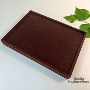 Macro view of velvet ring display tray slots showing textured brown flocking surface