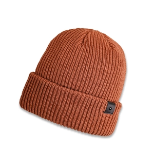Close-up of ribbed knit texture and favorite leather label on caramel orange beanie