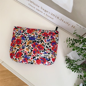 Detailed close-up of floral makeup bag featuring colorful fabric and a woven logo label