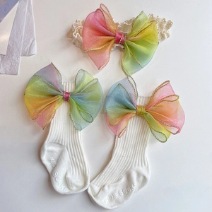 Detail of infant white ribbed cotton socks and headband set with rainbow organza bows