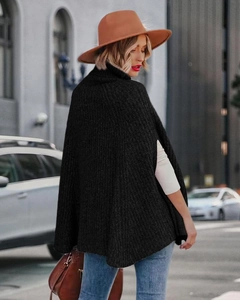 Dettaglio mantella in maglia nera con spacco laterale per donna in stile urbano moderno