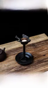 Detalle de un portavelas de pájaro de hierro fundido rústico con una vela sobre madera