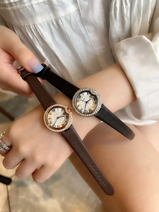 Detail of quartz watch with crystal bezel and Roman numerals on soft white shirt