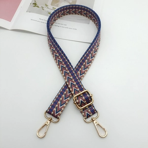 Close-up of adjustable chevron jacquard strap with gold metal hooks on white surface